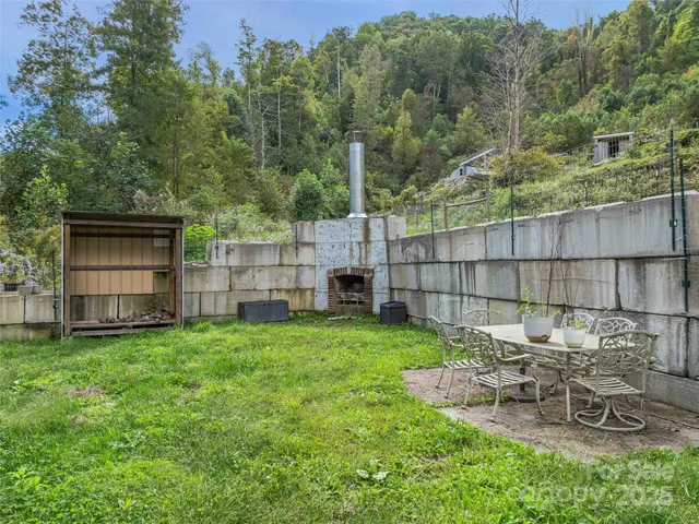 a view of a backyard with table and chairs and potted plants