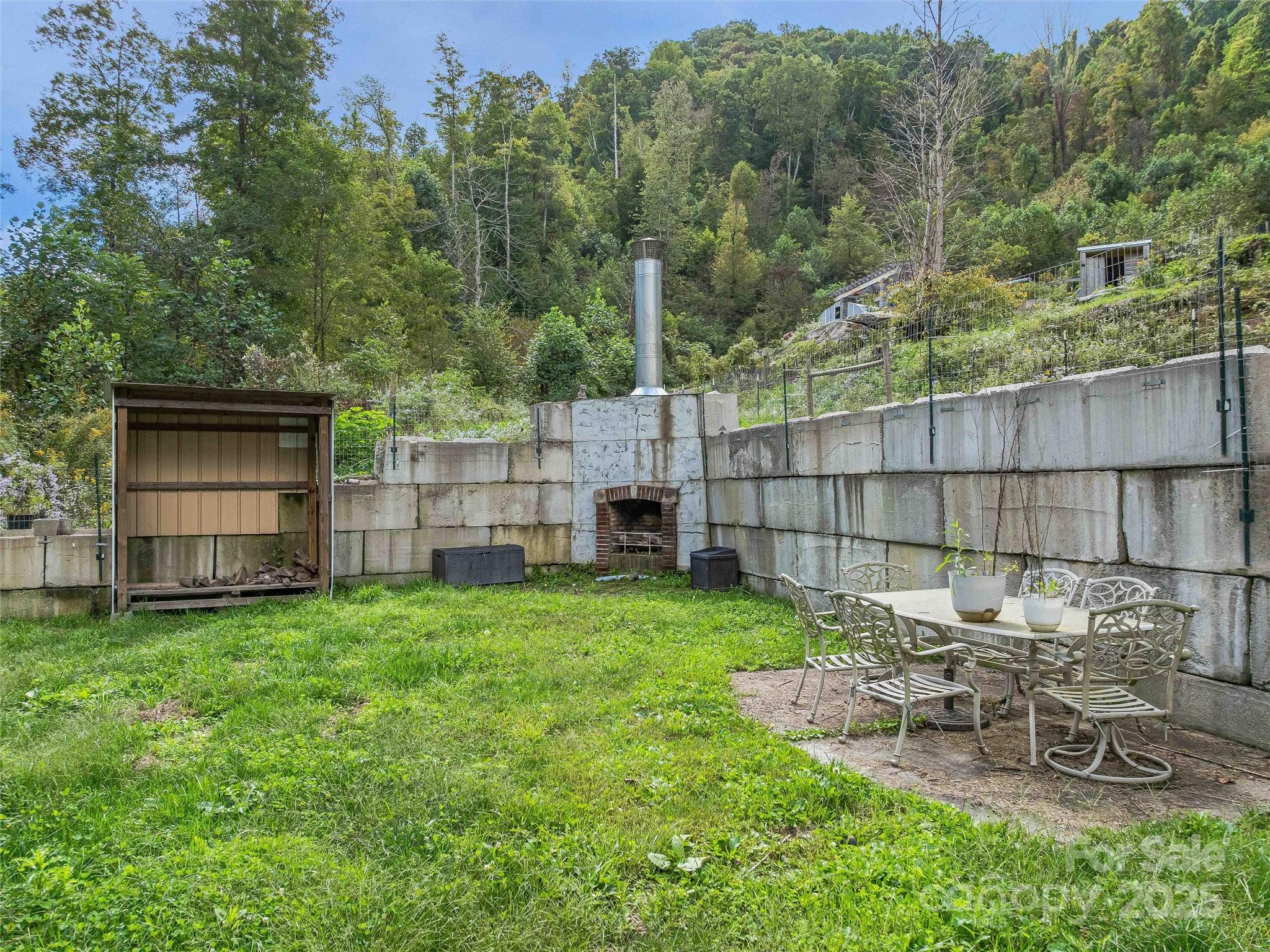945 Roaring Fork Road Hot Springs, NC 28743 - Photo 30 of 48 a view of a backyard with table and chairs and potted plants