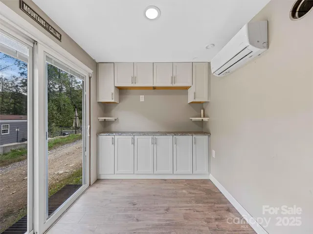 a view of a kitchen with wooden floor and a window
