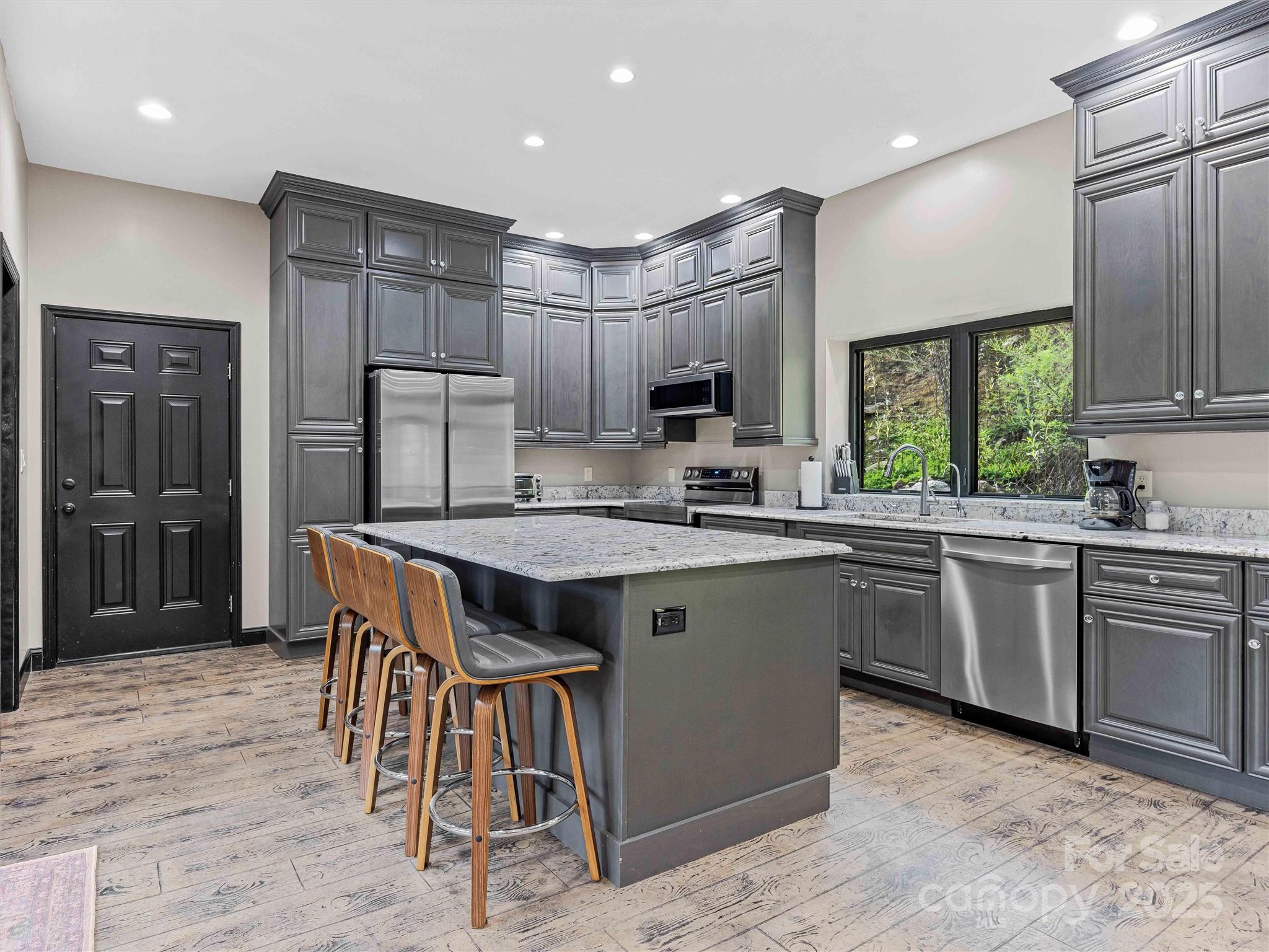 945 Roaring Fork Road Hot Springs, NC 28743 - Photo 7 of 48 a kitchen with kitchen island granite countertop wooden cabinets a refrigerator a stove a sink and a oven