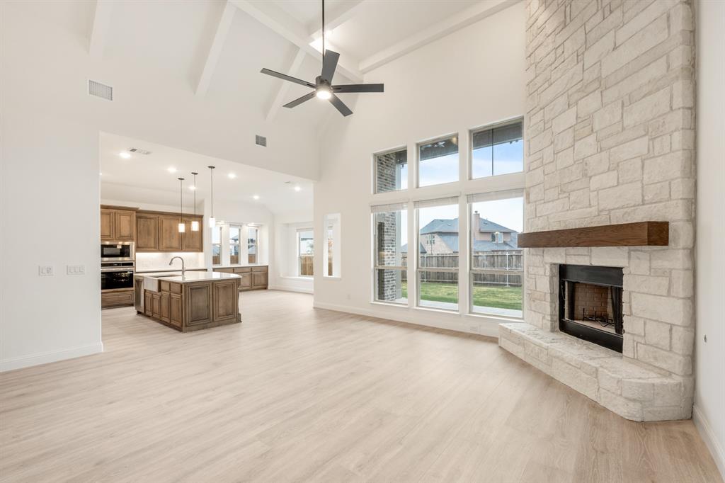 2824 Spg Vly Way Anna, TX 75409 - Photo 18 of 40 a view of a livingroom with a fireplace a ceiling fan and windows