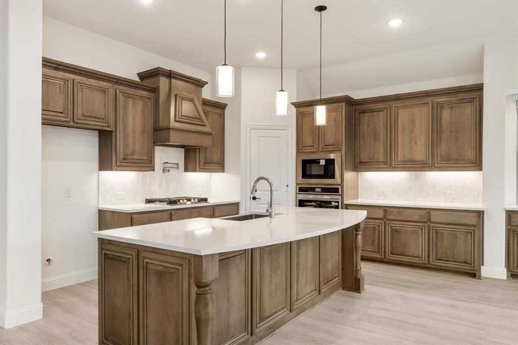 2824 Spg Vly Way Anna, TX 75409 - Photo 19 of 40 a kitchen with a sink a stove a refrigerator and cabinets