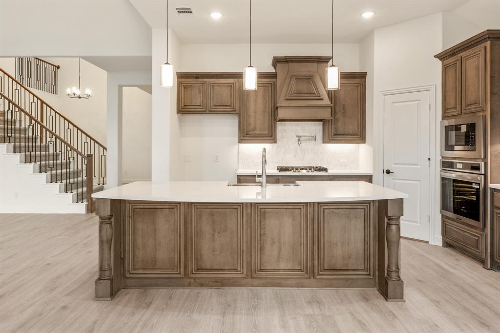 2824 Spg Vly Way Anna, TX 75409 - Photo 20 of 40 a kitchen with kitchen island a refrigerator and a sink