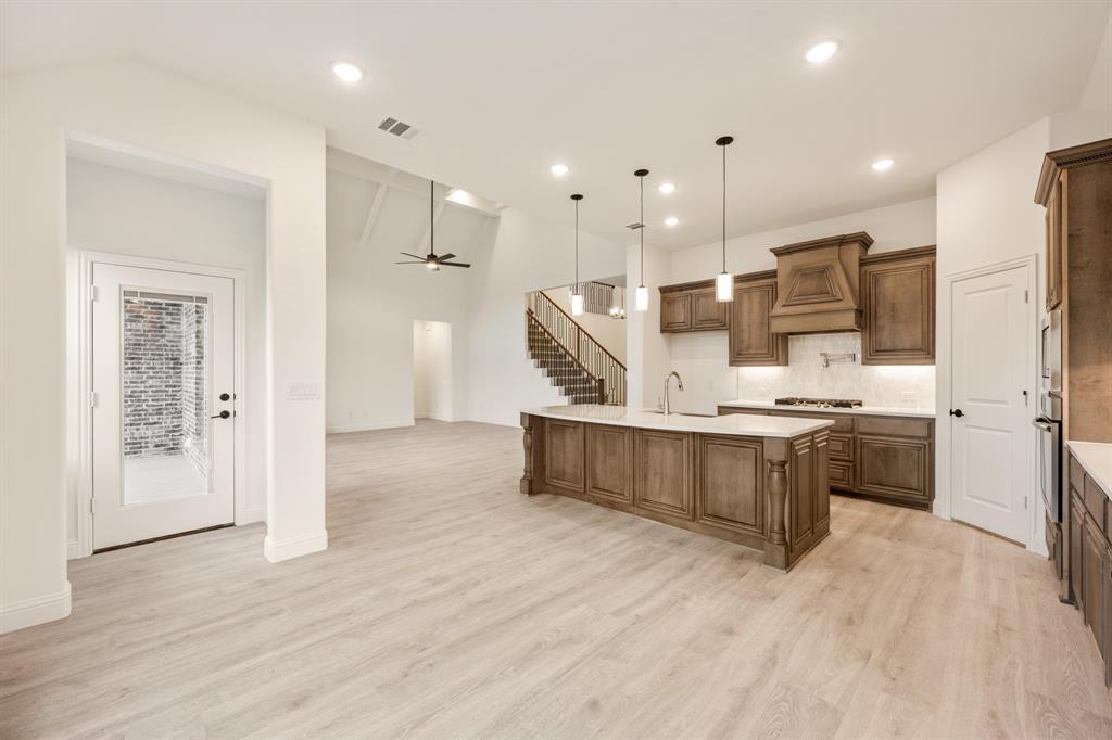 2824 Spg Vly Way Anna, TX 75409 - Photo 21 of 40 a large kitchen with stainless steel appliances kitchen island a large counter top and wooden floors