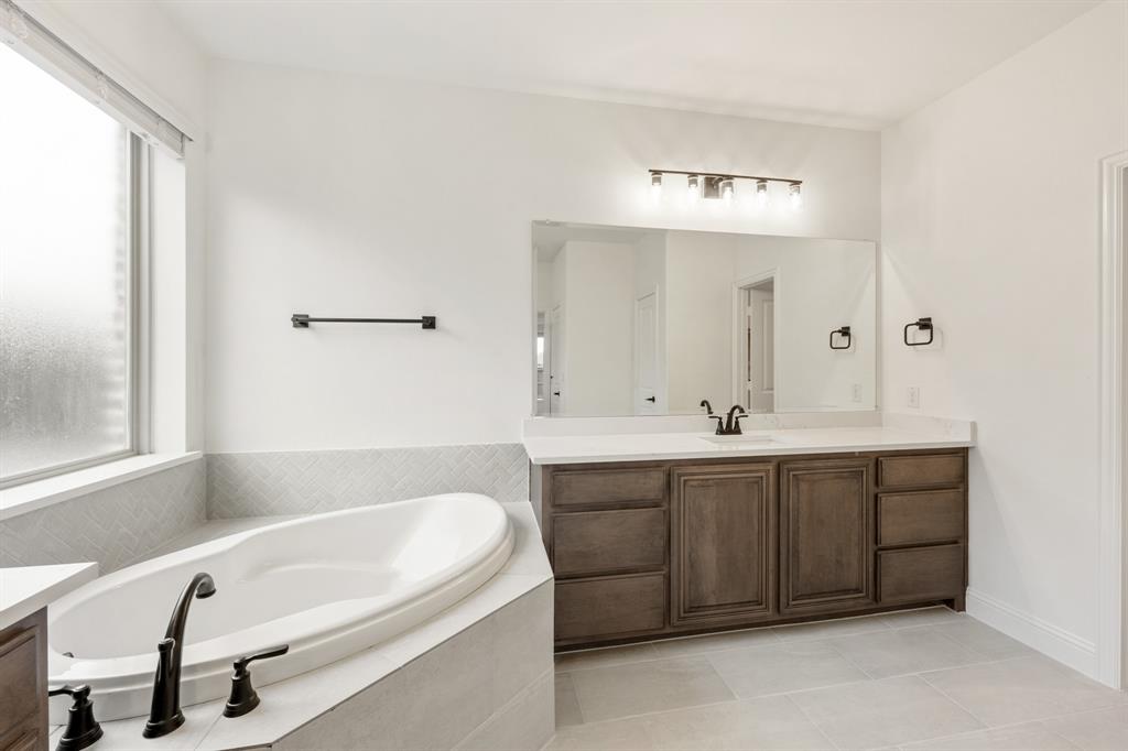 2824 Spg Vly Way Anna, TX 75409 - Photo 26 of 40 a bathroom with a tub sink and mirror