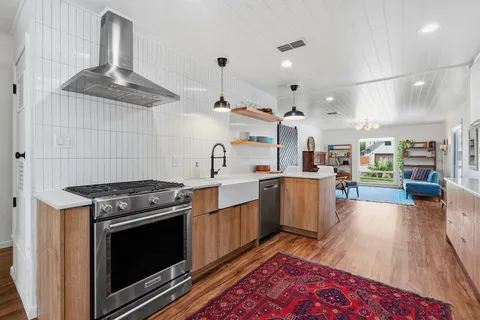 a view of a backyard with large trees and wooden fence