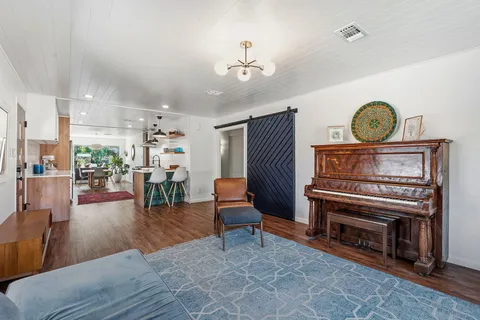 a kitchen with stainless steel appliances kitchen island granite countertop a table chairs and a wooden floor