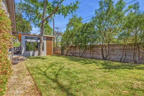 a backyard of a house with table and chairs