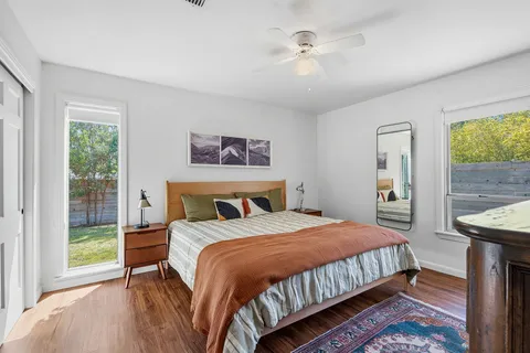 a bedroom with a bed a mirror and a window