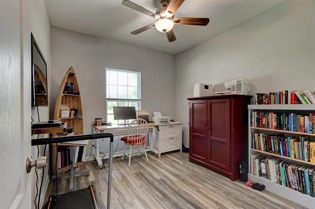 a view of a workspace with furniture and a bookshelf