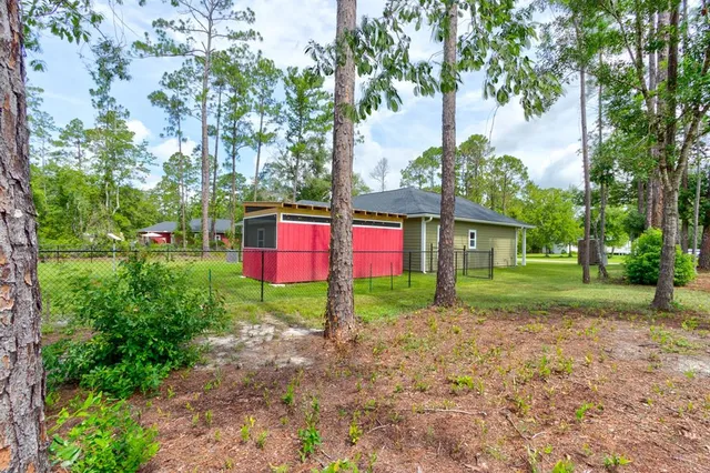a view of a yard with plants and trees