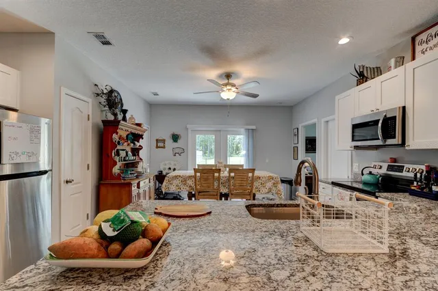 a living room with furniture a chandelier and a flat screen tv