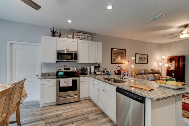 a kitchen with granite countertop a sink and cabinets