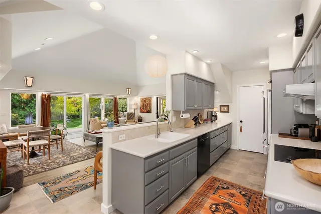 a kitchen with stainless steel appliances a sink a stove and a wooden floors