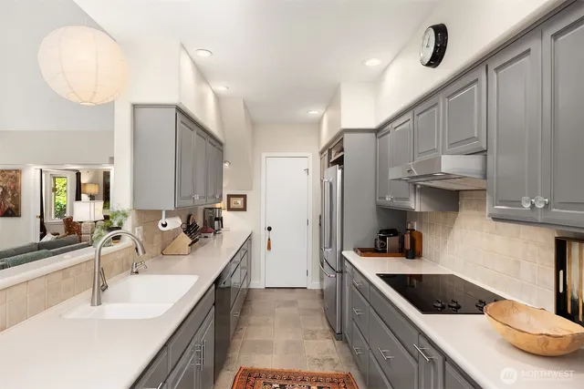 a kitchen with kitchen island a sink appliances and cabinets
