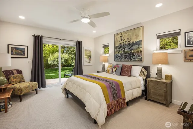 a bathroom with a double vanity sink a large mirror and a bathtub next to a window