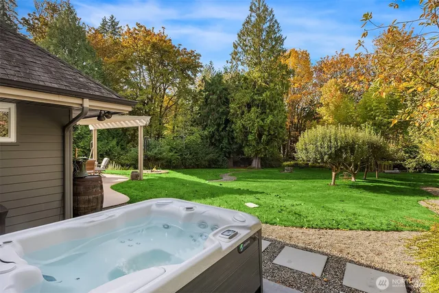 a view of a bathtub in a yard with wooden fence