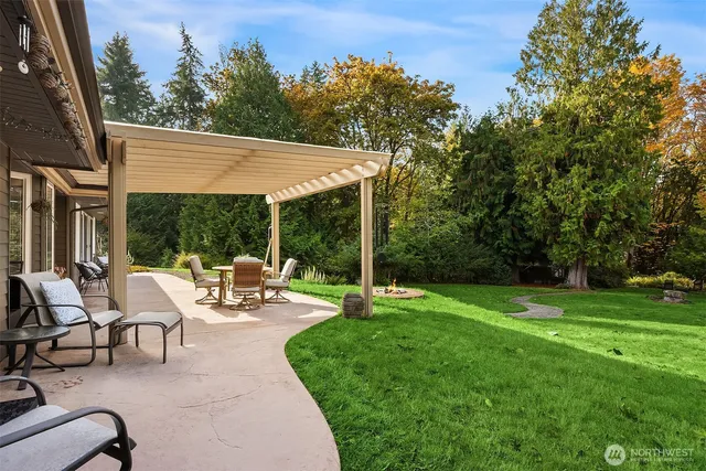 a view of a patio with a table chairs and a yard