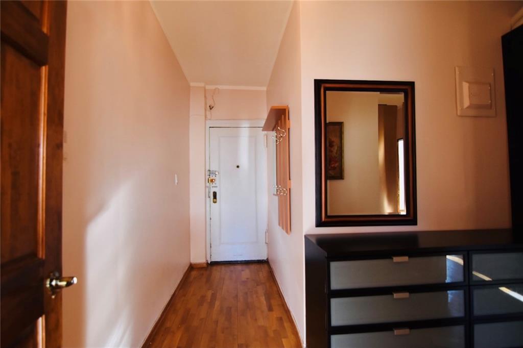 2940 Ocean Avenue, Unit A9 Brooklyn, NY 11235 - Photo 4 of 9 a view of a hallway with wooden floor and a mirror