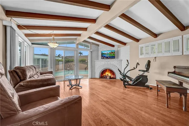 a living room with furniture a wooden floor and next to a window