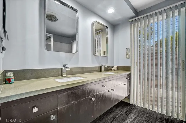 a bathroom with a granite countertop sink and a mirror