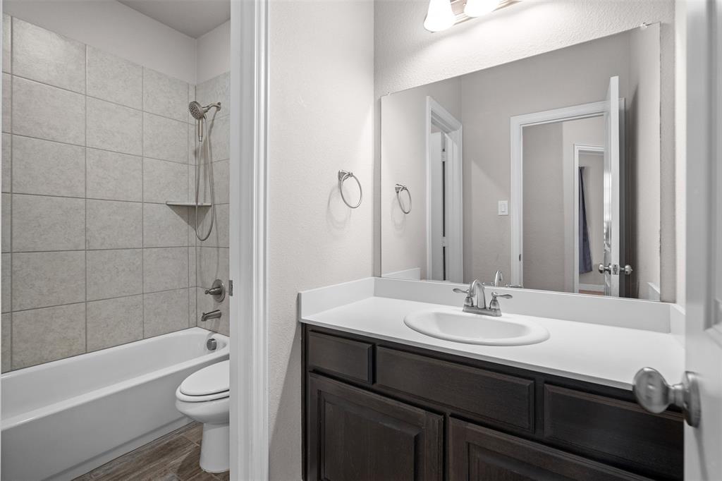 119 Happy Lane Red Oak, TX 75154 - Photo 32 of 37 Bathroom featuring a dark wood-finish vanity with a white countertop, an undermount sink, and a large wall-mounted mirror
