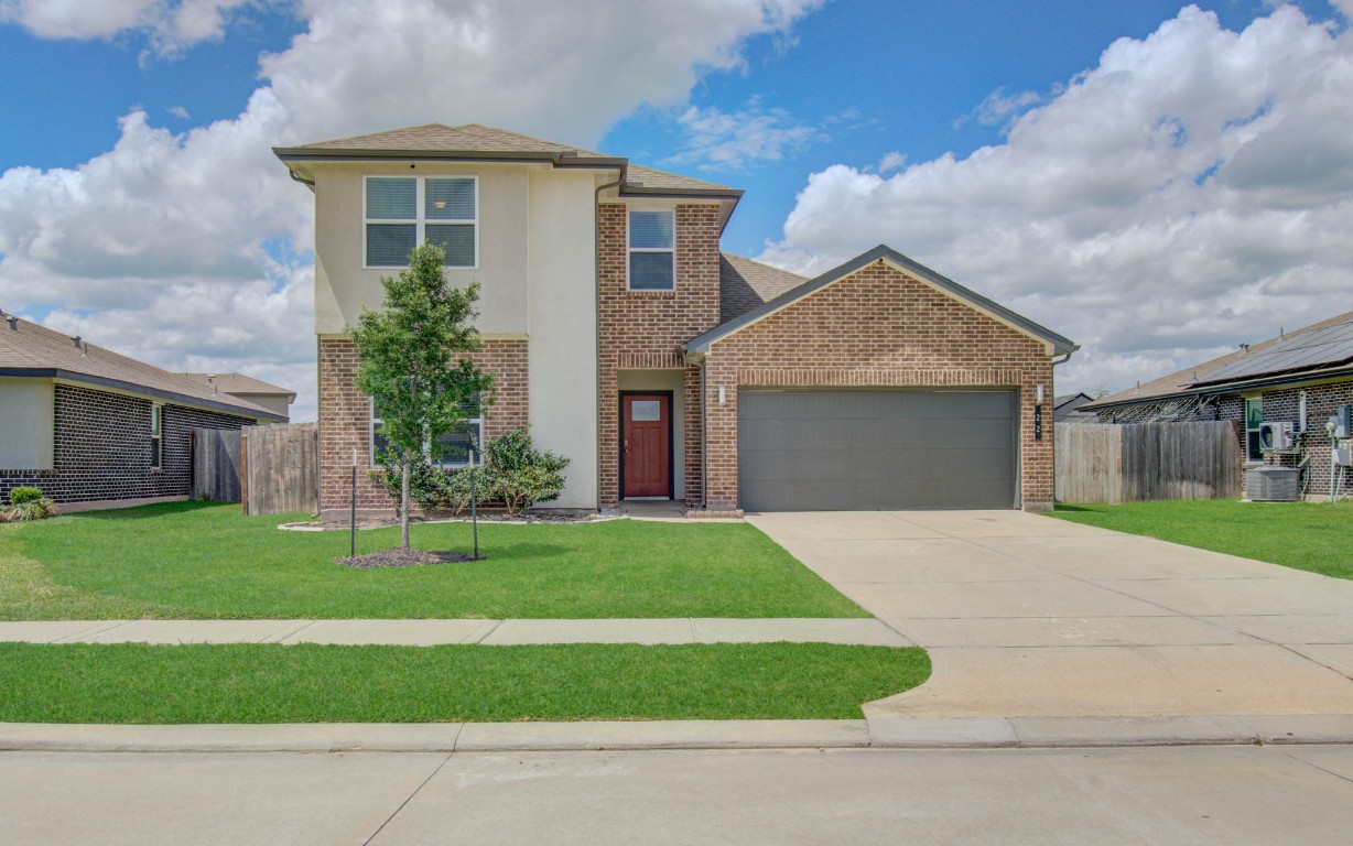 a front view of a house with a yard and garage