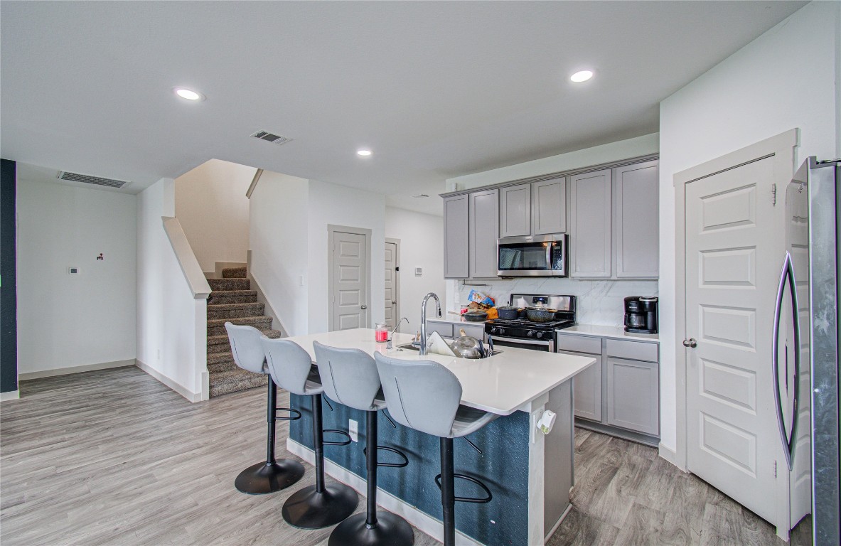 22 Desert Spring Lane Manvel, TX 77578 - Photo 6 of 39 a kitchen with a table chairs refrigerator and cabinets