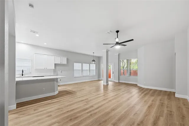 a view of an empty room and window and wooden floor