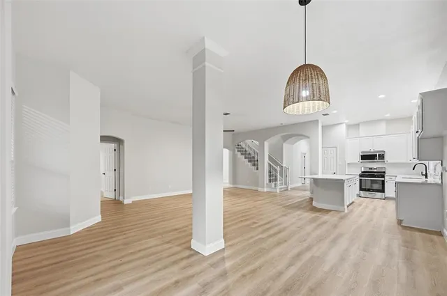 a view of a kitchen with wooden floor and stainless steel appliances