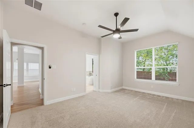 an empty room with fan and windows
