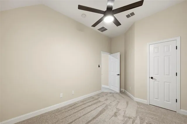 an empty room with chandelier fan