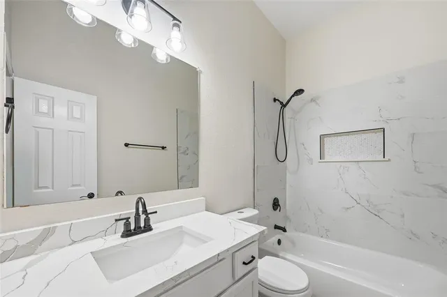 a bathroom with a granite countertop sink toilet and shower