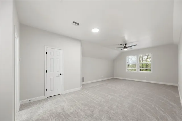 an empty room with windows and a ceiling fan