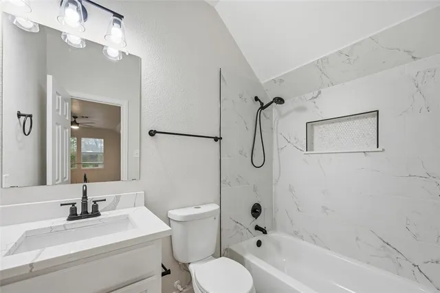 a bathroom with a granite countertop sink toilet and shower