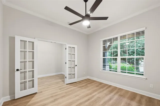 a view of an empty room with a window and wooden floor