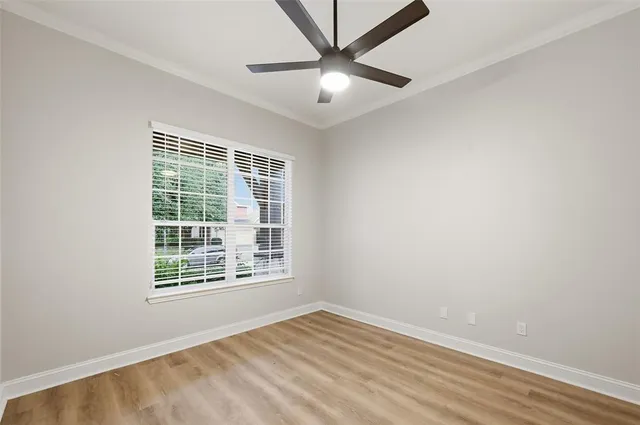 an empty room with a window and a fan