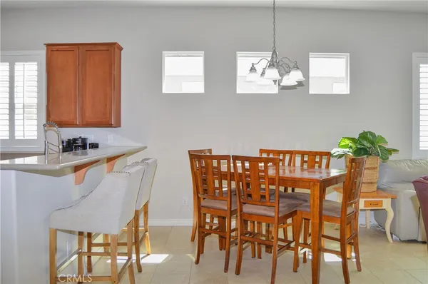 a living room with furniture a chandelier and a dining table