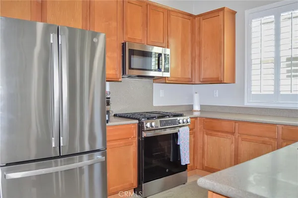 a kitchen with stainless steel appliances granite countertop a refrigerator a stove a sink and a microwave