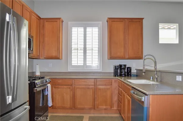 a kitchen with stainless steel appliances granite countertop a sink a stove and a refrigerator