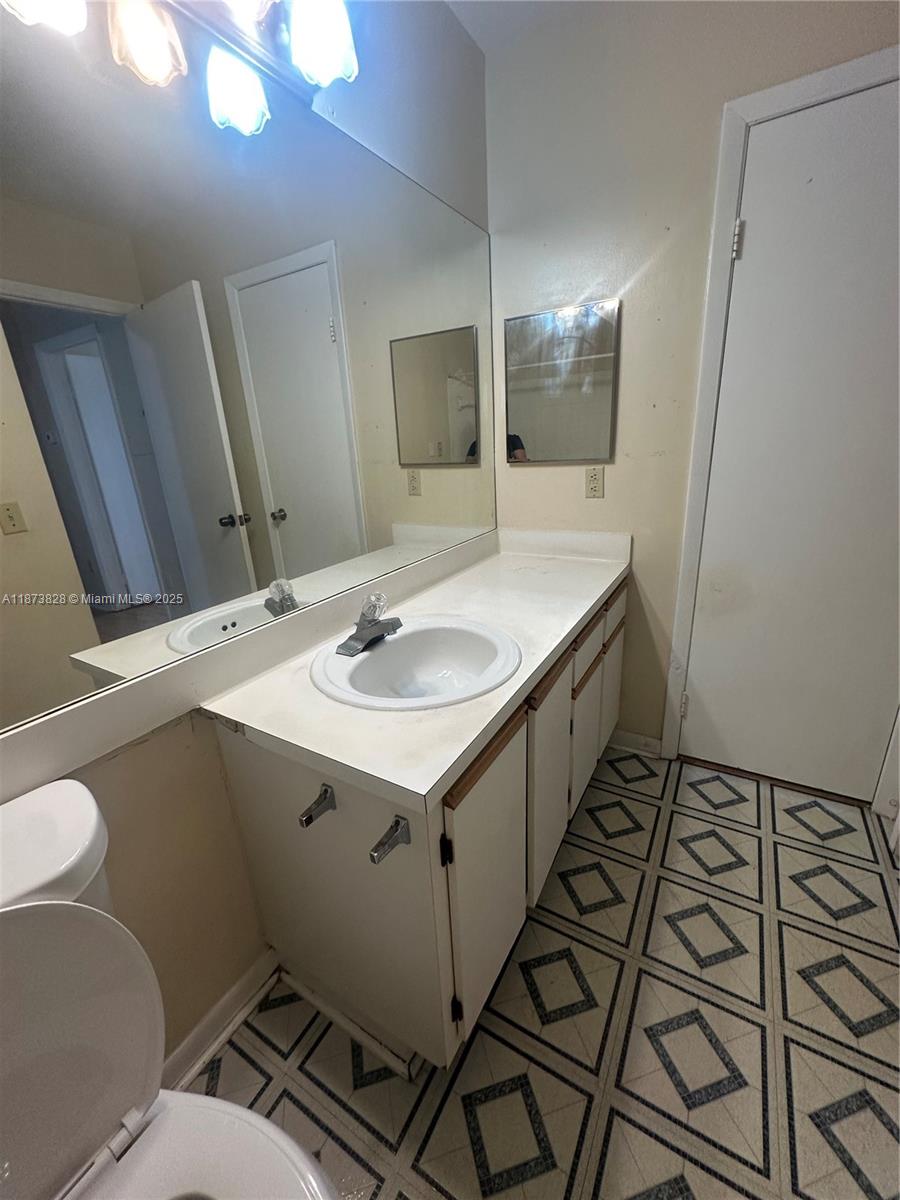18318 Northwest 68th Avenue, Unit B Hialeah, FL 33015 - Photo 15 of 26 a bathroom with sink mirror and toilet