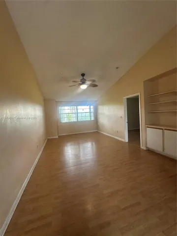 an empty room with windows and cabinet