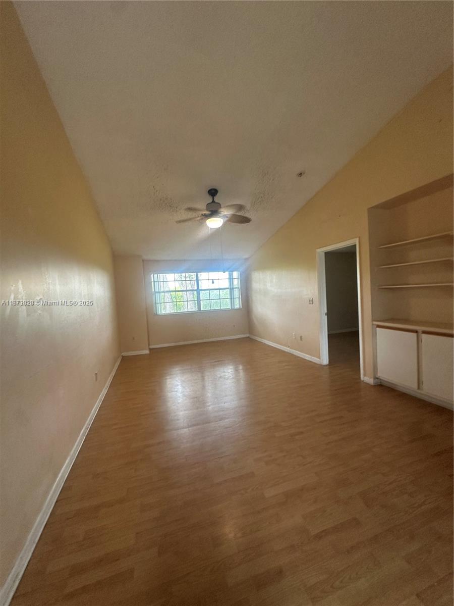 18318 Northwest 68th Avenue, Unit B Hialeah, FL 33015 - Photo 5 of 26 an empty room with windows and cabinet