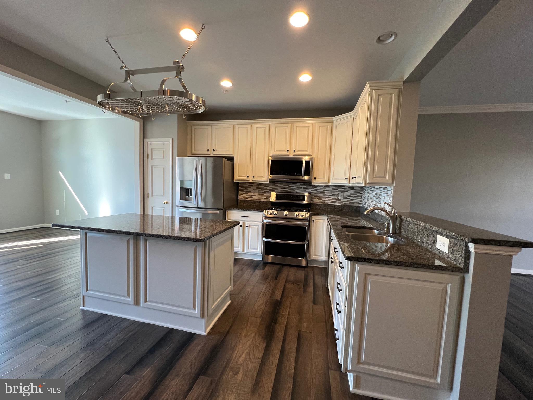 131 Fiona Way Brunswick, MD 21758 - Photo 21 of 73 a kitchen with kitchen island wooden floors appliances and cabinets