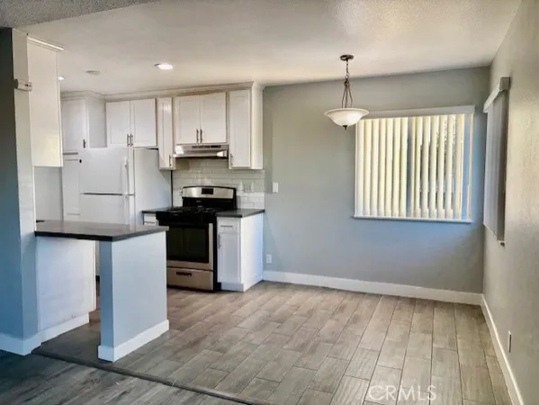 a kitchen with kitchen island white cabinets and refrigerator