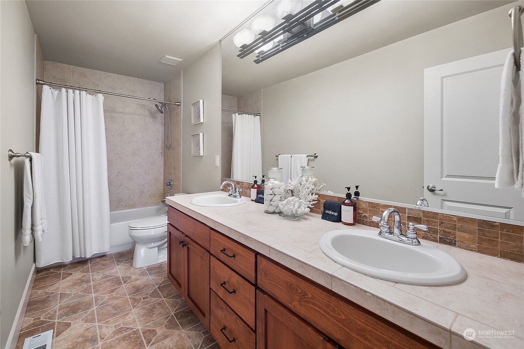 1020 West Ruffner Street Seattle, WA 98119 - Photo 31 of 39 a bathroom with a double vanity sink double mirror and a toilet