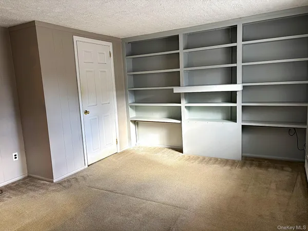 a room with a closet and wooden shelves