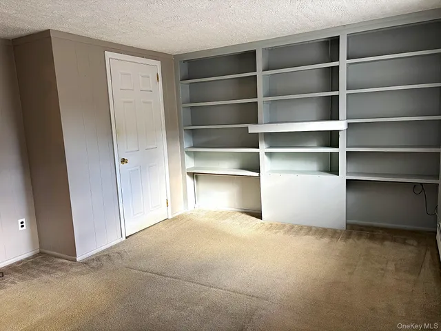 a room with a closet and wooden shelves
