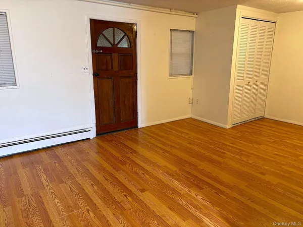 an empty room with wooden floor and closet