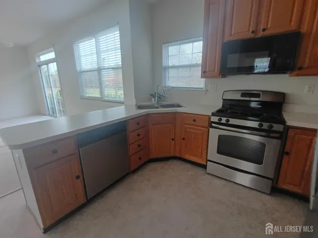 a kitchen with cabinets stainless steel appliances and a window